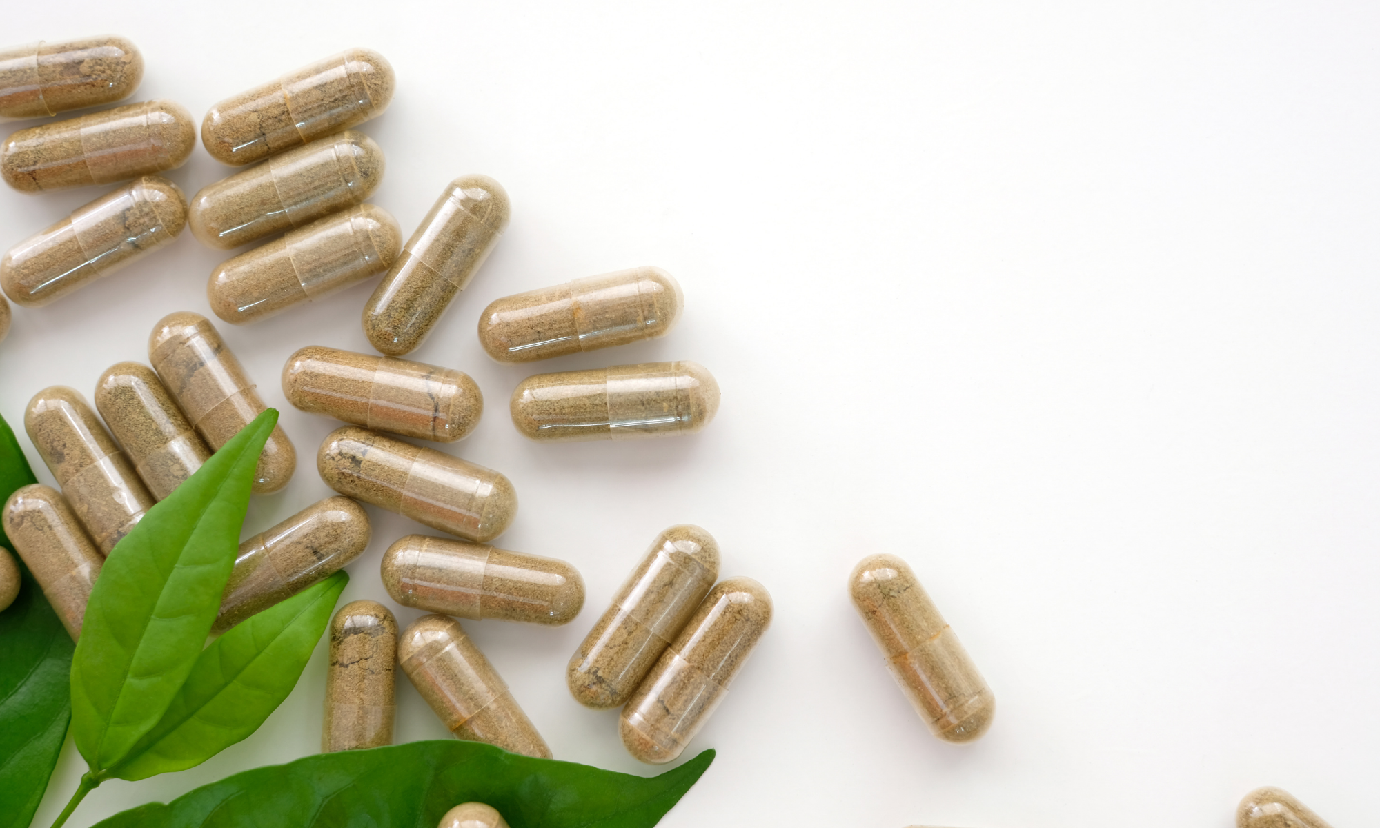 Fond mettant en scène des gélules extraites des boîtes de compléments alimentaires Sweet Control (contre les compulsions de sucre), posées au premier plan, avec une plante verte en arrière-plan, évoquant naturalité et bien-être.